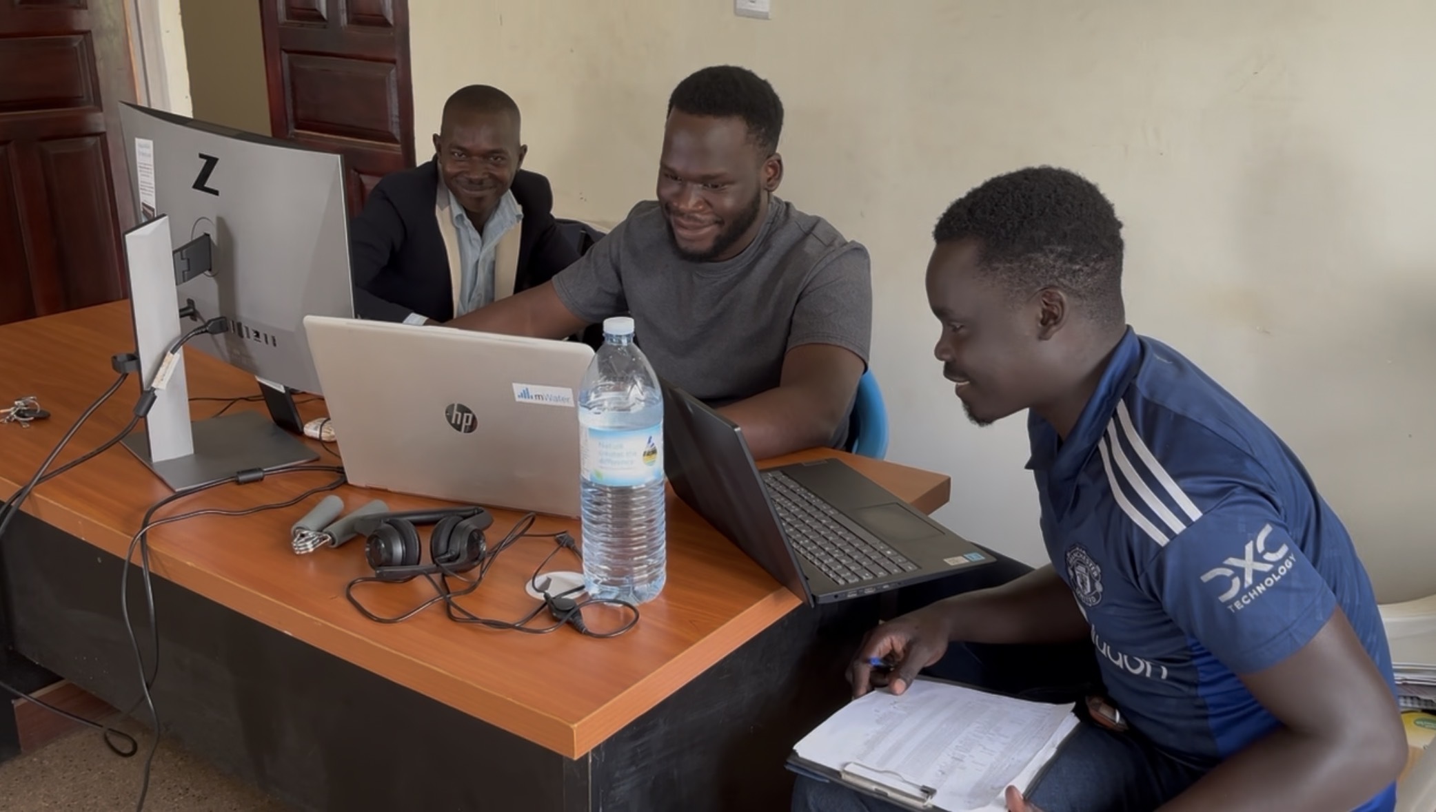 Analysts working together at laptops, one running mWater